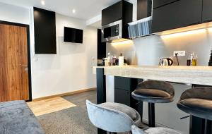 a kitchen with a counter and stools in a room at Airbnb à Paris-Bois de Vincennes in Saint-Maurice +5 photos