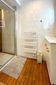 a bathroom with a shower and a wooden floor at Airbnb à Paris-Bois de Vincennes in Saint-Maurice