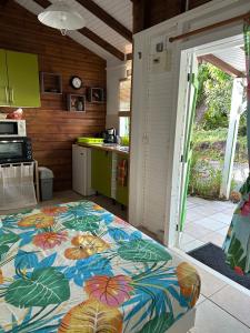 a kitchen with a bed in the middle of a room at Le ptit paradis créole in Sainte-Rose