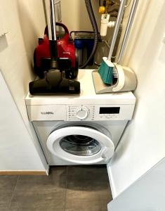 a vacuum cleaner sitting on top of a washing machine at Airbnb à Paris-Bois de Vincennes in Saint-Maurice
