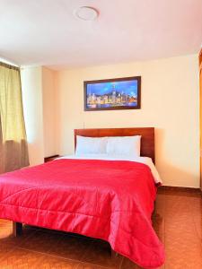 a bedroom with a red bed with a red blanket at Hotel Milenio Ipiales in Ipiales