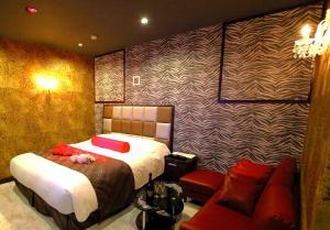 a bedroom with a bed and a couch at 岐阜ホテルヴィヴィ in Gifu