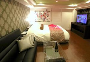 a bedroom with a bed and a glass table at 岐阜ホテルヴィヴィ in Gifu