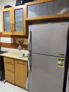 uma cozinha com uma geladeira branca e armários de madeira em Comfyshorouk em Darb al Ḩājj