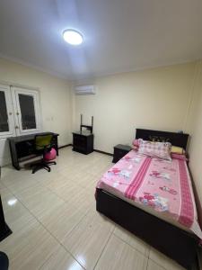 um quarto com uma cama, uma escrivaninha e uma cadeira em Comfyshorouk em Darb al Ḩājj