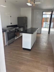 a kitchen with a black and white counter and refrigerator at Casa los Cipreses del Sol in Cieneguilla +25 photos