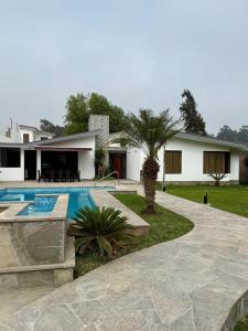 a villa with a swimming pool and a house at Casa los Cipreses del Sol in Cieneguilla
