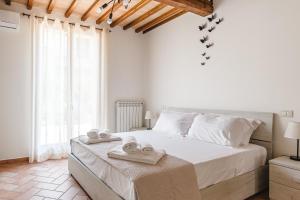 Un dormitorio con una cama grande con toallas. en Appartamento - Il Gelso, en Lucignano