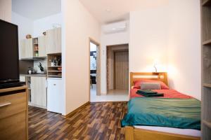 a small bedroom with a bed and a kitchen at Penzion a wellness U Třeboňské madony in Třeboň