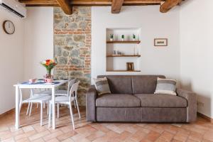 una sala de estar con un sofá y una mesa en Appartamento - Il Gelso, en Lucignano