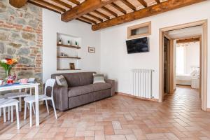 una sala de estar con un sofá y una mesa en Appartamento - Il Gelso, en Lucignano