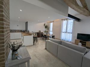 a living room with a couch and a table at La Remise loft de caractère et grand garage in Collobrières
