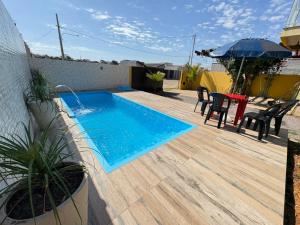 a swimming pool on a deck with a table and chairs at Casa Temporada Aconchego e tranquilidade 2 in Bonito