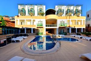 a building with a swimming pool in front of a building at Jasmin Beach Hotel in Gümbet