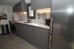 a kitchen with a stainless steel refrigerator and a sink at La Casita - Boutique Retreat Barcelona Coast Sea View in Sant Andreu de Llavaneres