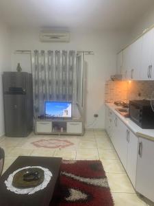 a kitchen with a television and a kitchen with a counter at Qetesia Apartment in Shkodër +5 photos