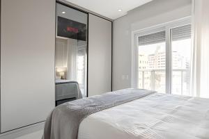 弗洛里亚诺波利斯Elegante apto Região Central Florianópolis/SC的一间带床和窗户的白色卧室