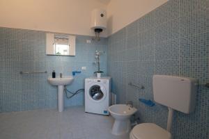 a bathroom with a toilet sink and a washing machine at Natoli Beach House & Villas Villa Manfredi in Molino San Biagio