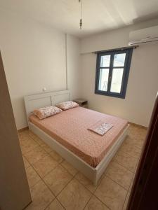 a bedroom with a bed and a window at Naousa house in Naousa