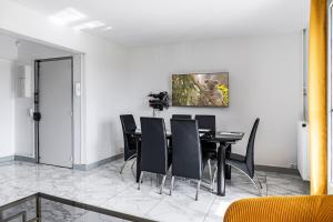 una sala da pranzo con un tavolo e sedie nere di Chambre lumineuse et cosy, bord de marne, proche Paris a Neuilly-sur-Marne Altre 3 foto