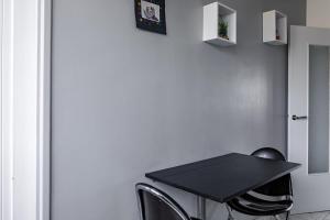 un tavolo nero e due sedie in una stanza di Chambre lumineuse et cosy, bord de marne, proche Paris a Neuilly-sur-Marne