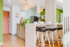 a kitchen with green walls and a counter with stools at Engaging 2BR rooftop view in Barranco in Lima