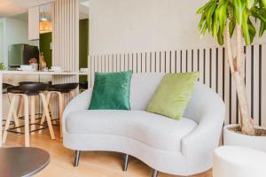 a living room with a white couch with two green pillows at Engaging 2BR rooftop view in Barranco in Lima +36 photos