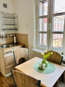 a kitchen with a table with a vase of flowers on it at Duży apartament z kuchnią i łazienką in Namysłów
