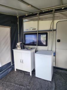 an interior of an rv with two white cabinets at Løgstør Camping in Løgstør +17 photos