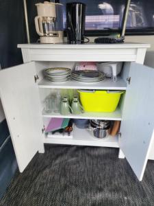a white cabinet with plates and dishes on it at Løgstør Camping in Løgstør