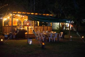 a table and chairs under a gazebo at night at Dordogne Glamping & Camping in Bouzic