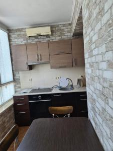 a kitchen with a table and a brick wall at Rohovska appartment in Odesa