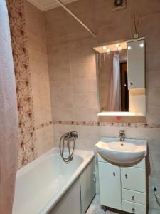 a bathroom with a sink and a bath tub and a sink at Rohovska appartment in Odesa