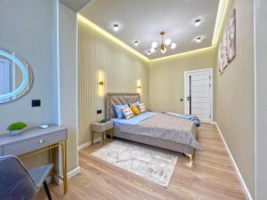 a bedroom with a bed and a table and a chair at Spacious Designer Apartment with a Scenic View in Almaty +9 photos