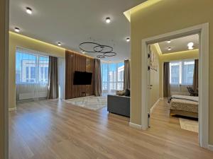 a living room with a couch and a flat screen tv at Spacious Designer Apartment with a Scenic View in Almaty