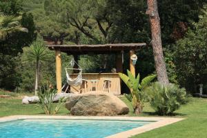a hammock hanging from a gazebo next to a pool at La Casita - Boutique Retreat Barcelona Coast Sea View in Sant Andreu de Llavaneres