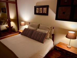 a bedroom with a bed with two lamps and a mirror at Garrett by the Sea in Vila do Conde
