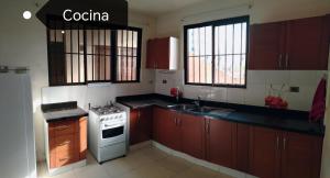 a kitchen with wooden cabinets and a white stove top oven at Zona Premium - Amplio Dep in Cochabamba