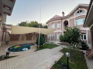 a large house with a swimming pool in the yard at MIMFRI PREMIUM guest house, hotel in Tashkent
