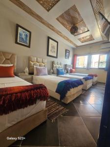 a large bedroom with two beds and a ceiling at Bluemoon house in Chefchaouen