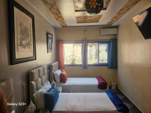 Un dormitorio con dos camas y una ventana. en Bluemoon house, en Chefchaouen