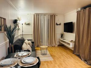una sala de estar con un sofá y una mesa en Smart stay entre la defense et paris, en Argenteuil 22 fotos más