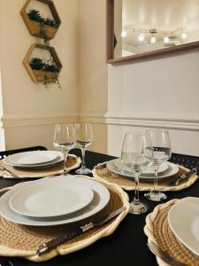 Una mesa con platos y copas de vino encima. en Smart stay entre la defense et paris, en Argenteuil