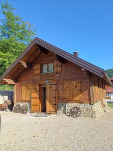 a large wooden cabin with a gambrel roof at Holiday house "Villa Dalia" in Bihać