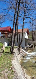 a white house with trees in front of it at Stari mlin - Old mill Šipovo in Šipovo