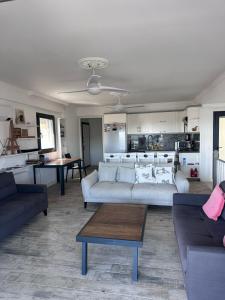 a living room with two couches and a kitchen at Seaside villa Sunrise Sea view, fully Private Pool in Akyarlar