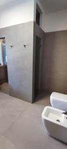 a bathroom with a white toilet and a sink at Villeriunite - Villa Dalia in Baia Verde