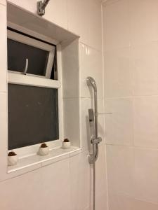 a bathroom with a shower and a window with cactuses at Large Family Home, Pet Friendly, 4 Bed 2 Bath House, Sleeps 10, Free Wi-Fi, Free Parking in Dagenham Dock