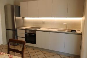 a kitchen with white cabinets and a sink and a stove at Villeriunite - Villa Dalia in Baia Verde