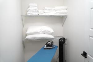 卡尔加里The Cozy Nook of Seton的房间里有一个架子，上面放着毛巾，还有一张蓝色的长凳